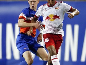 FILE - In this Aug. 15, 2017, file photo ,New York Red Bulls midfielder Tyler Adams, right, shields for the ball against FC Cincinnati midfielder Jimmy McLaughlin, left, during the second half of a U.S. Open Cup semifinal soccer match in Cincinnati. Josh Sargent remembered when coach John Hackworth greeted the U.S. Under-17 team at breakfast in India last month and told players the American senior team had failed to qualify for next year's World Cup. "Everybody thought he was joking," Sargent said. In the wake of the failure, Sargent has been promoted to the national team along with Weston McKennie and Tyler Adams for Tuesday's exhibition at Portugal.  (AP Photo/John Minchillo, File)
