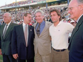 FILE - In this April 6, 1996, file photo, Major League Soccer luminaries, from right, owners representative Lamar Hunt, actor Andrew Shue, MLS Commissioner Douglas Logan, Chairman Alan Rothenberg, and FIFA representative Joao Havelange, gather on the field before the start of the league's inaugural game in San Jose, Calif. Launched with 10 teams in 1996, two years after the U.S. hosted the World Cup, MLS expanded to 12 but cut back to 10 after the 2001 season. There has been steady growth since expansion started in 2004. Next year's total will be 23, already well over the norm for a first division, and the league is planning to settle at 28.  (AP Photo/Craig Fujii, File)