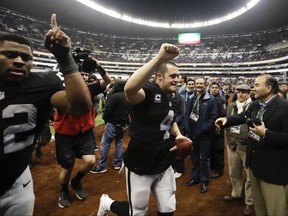 FILE - In this Nov. 21, 2016, file photo, Oakland Raiders quarterback Derek Carr, center, and defensive end Khalil Mack (52) leave the field after an NFL football game against the Houston Texans in Mexico City. The Raiders return to Mexico City to face the New England Patriots this week. (AP Photo/Eduardo Verdugo, File)