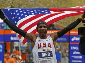 FILE - In this Nov. 1, 2009, file photo, Meb Keflezighi holds a U.S. flag after winning the men's division of the New York City Marathon. Keflezighi is retiring after the New York City Marathon on Sunday, Nov. 5, 2017, capping a career as the only person to win an Olympic medal and New York and Boston titles. (AP Photo/Kathy Willens, File)