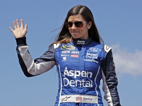 FILE - In this July 16, 2017, file photo, driver Danica Patrick waves prior to the NASCAR Cup Series auto race at the New Hampshire Motor Speedway in Loudon, N.H. Patrick announced plans Friday, Nov. 17, 2017, to run just 2 races in 2018, the Daytona 500 and the Indianapolis 500, and end her full-time driving career.  (AP Photo/Charles Krupa, File)