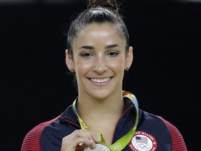 FILE - In this Aug. 16, 2016, file photo, United States' Aly Raisman shows off her silver medal after the artistic gymnastics women's apparatus final at the 2016 Summer Olympics in Rio de Janeiro, Brazil. Six-time Olympic medal winning gymnast Aly Raisman says she is among the young women abused by a former USA Gymnastics team doctor.  Raisman tells "60 Minutes" she was 15 when she was first treated by Dr. Larry Nassar, who spent more than two decades working with athletes at USA Gymnastics but now is in jail in Michigan awaiting sentencing after pleading guilty to possession of child pornography. (AP Photo/Dmitri Lovetsky, FIle)