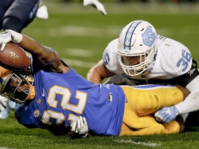 In this Thursday, Nov. 9, 2017 file photo, Pittsburgh running back Darrin Hall (22) stretches to try to score as North Carolina linebacker Cole Holcomb (36) tackles him during the second half of an NCAA college football game in Pittsburgh. Miami plays Pittsburgh, Friday, Nov. 24, 2017. (AP Photo/Keith Srakocic, File)