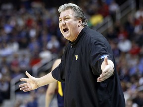 FILE - In this March 23, 2017, file photo, West Virginia head coach Bob Huggins yells from the sideline during the first half of an NCAA Tournament college basketball regional semifinal game against Gonzaga in San Jose, Calif. Huggins has agreed to a four-year contract extension the 2021-22 season. The 64-year-old Huggins will earn $3.75 million this season, including a base salary of $250,000. Under the agreement, starting with the in 2022-23 season, Huggins can assume a five-year appointment in public relations and development along with other duties within the athletic department, ending in June 2027. Or Huggins can choose to continue serving as head coach.  (AP Photo/Tony Avelar, File)