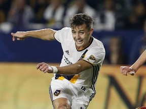 FILE - In this Oct. 26, 2016, file photo, Los Angeles Galaxy forward Robbie Rogers kicks the ball against a Real Salt defender during the second half of a knockout round MLS playoff soccer match in Carson, Calif. Rogers, the LA Galaxy defender who became the first openly gay male athlete in a major North American professional sport, is retiring from soccer. The 30-year-old Rogers announced his retirement Tuesday, Nov. 7, 2017, through the Galaxy, saying he made the decision "with mixed emotions." (AP Photo/Alex Gallardo, File)