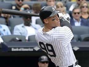 FILE - In this Wednesday, Sept. 20, 2017 file photo, New York Yankees' Aaron Judge follows through on a two-run home run during the third inning of a baseball game against the Minnesota Twins at Yankee Stadium in New York. Yankees slugger Aaron Judge is a finalist for AL MVP and Rookie of the Year, giving him a chance to become just the third player to win the awards in the same year. The Baseball Writers' Association of America revealed the finalists for its major awards on Monday night, Nov. 6, 2017. (AP Photo/Bill Kostroun, File)