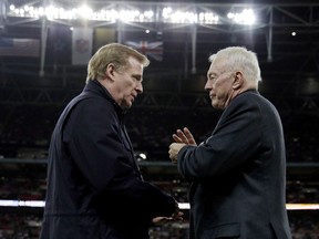 FILE - In this Nov. 9, 2014, file photo, NFL Commissioner Roger Goodell, left, and Dallas Cowboys owner Jerry Jones talk at the NFL football game between the Jacksonville Jaguars and the Cowboys at Wembley Stadium in London. Jones has threatened to sue the NFL over a proposed contract extension for Goodell, a dispute apparently sparked by star running back Ezekiel Elliott's six-game suspension over alleged domestic violence, a person with knowledge of the situation told The Associated Press on Wednesday, Nov. 8, 2017. (AP Photo/Matt Dunham, File)