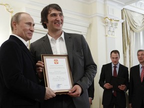 FILE - In this May 29, 2012, file photo, Russian national ice hockey team member Alexander Ovechkin, right, holds a certficate of recognition given to him by President Vladimir Putin, left, in the Novo-Ogaryovo residence outside Moscow. Washington Capitals captain Alex Ovechkin has voiced his support for Vladimir Putin ahead of the upcoming Russian presidential elections. Ovechkin posted a message in Russian on his Instagram account Thursday, Nov. 2, 2017,  announcing he's starting "a social movement called Putin Team." From right in the background are Russian ice hockey federation president Vladislav Tretyak and Russia's captain Ilya Nikulin. (AP Photo/Sergei Karpukhin, Pool, File)