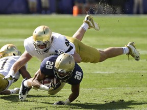 FILE - In this Nov. 5, 2016, file photo, Notre Dame linebacker Greer Martini, top, brings down Navy running back Dishan Romine (28) after a short gain during the first half of an NCAA college football game in Jacksonville, Fla. Notre Dame's turnaround season took a detour last week. The ninth-ranked Fighting Irish have no time to wallow in misery, either, not with Navy visiting on Saturday. "You got to be at the right place in the right timing against an offense like this and if you're not, they exploit you," senior linebacker and captain Greer Martini said. (AP Photo/John Raoux)