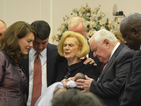 FILE - In this 2012 photo provided by a former member of the church, Word of Faith Fellowship leader Jane Whaley, center, holds a baby with her husband, Sam, center right, and others during a ceremony in the church's compound in Spindale, N.C. Under the leadership of Jane Whaley, the controversial church has grown to about 750 congregants in Spindale and a total of nearly 2,000 members worldwide. (AP Photo)