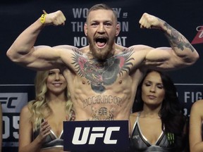 FILE - In this Friday, Nov. 11, 2016, file photo, Conor McGregor stands on a scale during the weigh-in event for his fight against Eddie Alvarez in UFC 205 mixed martial arts at Madison Square Garden in New York. UFC President Dana White says he's unsure how long Connor McGregor can keep his lightweight title without defending it. White told The Associated Press, "that's what we have to figure out," in a telephone interview, Thursday, Nov. 30, 2017, days before UFC 218 in Detroit. (AP Photo/Julio Cortez, File)