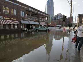 FILE - In this Wednesday, May 5, 2010 photo, downtown businesses are reflected in floodwaters from the Cumberland River in Nashville, Tenn. A study released Monday, Nov. 20, 2017 predicts that summer thunderstorms in North America will likely be larger, wetter and more frequent in a warmer world, dumping 80 percent more rain in some areas and worsening flooding. (AP Photo/M. Spencer Green, File)