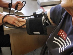 FILE - In this June 6, 2013, file photo, a patient has her blood pressure checked by a registered nurse in Plainfield, Vt. New medical guidelines announced Monday, Nov. 13, 2017, lower the threshold for high blood pressure, adding 30 million Americans to those who have the condition. (AP Photo/Toby Talbot, File)