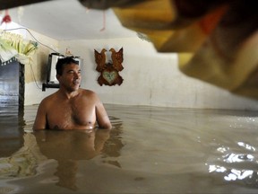 FILE - In this Jan. 25, 2012, file photo, Carlos Murcia stands in his flooded home in Juanchito, in southern Colombia. Meteorologists blame torrential rains on La Nina. The National Oceanic and Atmospheric Administration said Thursday, Nov. 9, 2017 that a weak La Nina has formed and is expected to stick around for several months. (AP Photo/Carlos Julio Martinez, File)