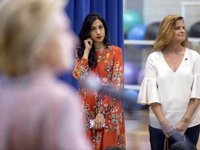 FILE - In this Thursday, Sept. 15, 2016 file photo, senior aide Huma Abedin, center, and Director of Communications Jennifer Palmieri, right, stand nearby as Democratic presidential candidate Hillary Clinton answers a question after a rally in Greensboro, N.C. On the 22nd, 23rd and 25th of March 2016, three volleys of malicious messages were generated targeting Abedin and Palmieri, among many others. (AP Photo/Andrew Harnik)