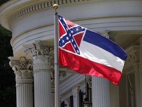 FILE - In this June 23, 2015, file photo, the Mississippi state flag is unfurled against the front of the Governor's Mansion in Jackson, Miss. The U.S. Supreme Court on Monday, Nov. 27, 2017, rejected an appeal from African-American attorney Carlos Moore who called the Confederate battle emblem on the Mississippi flag "an official endorsement of white supremacy." The justices did not comment as they ended the lawsuit by Moore that sought to have the flag declared an unconstitutional relic of slavery. (AP Photo/Rogelio V. Solis, File)
