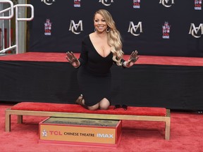 FILE - In this Wednesday, Nov. 1, 2017, file photo, Mariah Carey poses for photographers during her hand and footprint ceremony at the TCL Chinese Theatre in Los Angeles. Carey, the artist with the most No. 1 hits on the Billboard Hot 100 chart, is one of the nominees for the 2018 Songwriters Hall of Fame. (Photo by Jordan Strauss/Invision/AP, File)