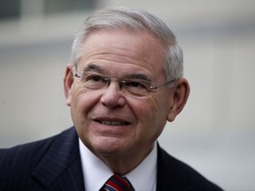 FILE - In this Nov. 16, 2017, file photo, U.S. Sen. Bob Menendez answers a question from a reporter before entering the Martin Luther King Jr. Federal Courthouse for his federal corruption trial, in Newark, N.J. Menendez's political fate in next year's crucial midterms after the mistrial in his federal bribery case may hinge on whether prosecutors retry him and whether attacks from Republicans based on the indictment convince voters to keep him from a third term. (AP Photo/Julio Cortez, File)