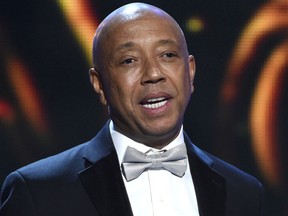 FILE - In this Feb. 6, 2015, file photo, hip-hop mogul Russell Simmons presents the Vanguard Award on stage at the 46th NAACP Image Awards in Pasadena, Calif. In a report published Sunday, Nov. 19, 2017, in the Los Angeles Times, Model Keri Claussen Khalighi accused Simmons of sexual misconduct in 1991 when she was 17-years-old. Simmons, denied the allegations in a statement. (Photo by Chris Pizzello/Invision/AP, File)