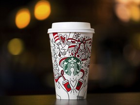 This Monday, Oct. 23, 2017, photo provided by Starbucks shows the company's 2017 holiday cup on display in Seattle. This latest holiday cup is mostly white, for customers to color in themselves. (Joshua Trujillo/Starbucks via AP)