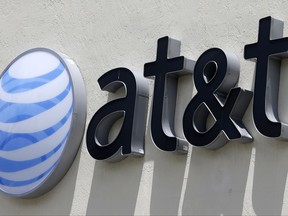 FILE - This Thursday, July 27, 2017, file photo shows an AT&T logo at a store in Hialeah, Fla. AT&T now says it's "uncertain" when its $85 billion Time Warner purchase will close. AT&T had maintained that the deal would be done by the end of 2017. (AP Photo/Alan Diaz, File)