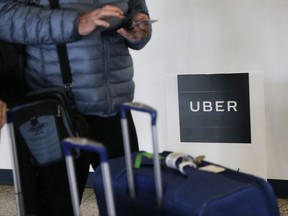 FILE - In this Wednesday, March 15, 2017, file photo, a traveler tries to book a ride with Uber at LaGuardia Airport in New York. Through a string of almost weekly scandals, Uber has managed to continue growing and hold onto the title of the world's largest ride-hailing service. In the latest misbehavior, hackers were able to steal data for 57 million riders and drivers, and Uber concealed it for a year. Riders and business experts say that hits people directly, and they won't be happy about it. (AP Photo/Seth Wenig, File)
