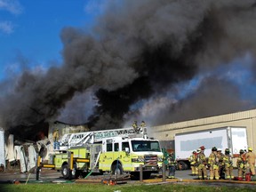 Firefighters work at the scene of of a fire Monday, Nov. 20, 2017, at the Verla International cosmetics factory on Temple Hill Road in New Windsor, N.Y. Authorities say two explosions and a fire at the cosmetics factory in the Hudson Valley have left numerous people injured, including firefighters caught in the second blast. (Jerry Barao via AP)