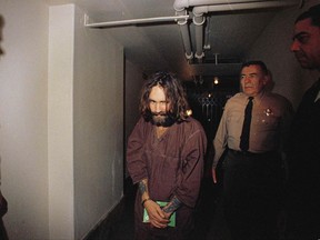 FILE - In this 1969 file photo, Charles Manson is escorted to court in Los Angeles during an arraignment phase. Authorities say Manson, cult leader and mastermind behind 1969 deaths of actress Sharon Tate and several others, died on Sunday, Nov. 19, 2017. He was 83. (AP Photo, File)