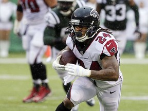 FILE - In this Oct. 29, 2017, file photo, Atlanta Falcons running back Devonta Freeman (24) runs after making a catch during the first half of an NFL football game against the New York Jets in East Rutherford, N.J. As the Falcons prepare for a big NFC showdown with Minnesota, Freeman was removed from concussion protocol on Wednesday, Nov. 29, 2017, after missing the last two games.  (AP Photo/Seth Wenig, File)