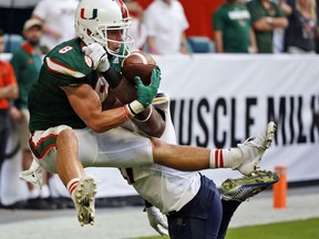 FILE - In this Sept. 23, 2017, file photo, Miami wide receiver Braxton Berrios (8) catches a touchdown pass against Toledo safety DeDarallo Blue (21) during the second half of an NCAA College football game in Miami Gardens, Fla. Berrios has more touchdown catches already this season than in his first three years with the seventh-ranked and unbeaten Hurricanes. He's broken out at the right time for Miami, which takes on No. 3 Notre Dame this weekend in a showdown with national championship implications.  (AP Photo/Wilfredo Lee, File)