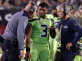 FILE - In this Thursday, Nov. 9, 2017, file photo, Seattle Seahawks quarterback Russell Wilson (3) speaks with head coach Pete Carroll, right, and assistant head coach Tom Cable during an NFL football game against the Arizona Cardinals in Glendale, Ariz. The Seahawks return to practice Tuesday, Nov. 14, 2017, without Richard Sherman and facing questions about how the team handled the concussion protocol with quarterback Russell Wilson. (AP Photo/Rick Scuteri, File)