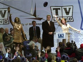 FILE - In this May 8, 2002 file photo, Mary Tyler Moore, right, tosses her hat in the air at the unveiling of a bronze statue of her character on the 1970s hit television series "The Mary Tyler Moore Show," at Nicollet Mall in downtown Minneapolis. The statue was returned to its original location at Nicollet Mall after it had been removed during a $50 million mall reconstruction project. (AP Photo/Dawn Villella, File)