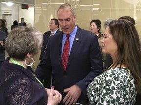 FILE - In this March 3, 2017, file photo, newly sworn-in Interior Secretary Ryan Zinke, with his wife Lola, right, greets an Interior Department employee on the Interior Department's 168th birthday at the Interior Department in Washington. Documents obtained by a left-leaning group show that Zinke's wife played a key role in arranging aspects of her husband's official events and often accompanied him on trips outside of Washington D.C. during the first few months of the administration. (AP Photo/Matthew Daly, File)