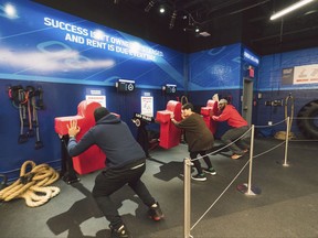 In this undated photo provided by NFL Experience Times Square, participants use football practice equipment installed at NFL Experience Times Square in New York. The $30 million project has taken 2 1/2 years to develop and has something for kids, teens and adults, mixing high tech and traditional displays into an immersive attraction. (NFL Experience Times Square via AP)