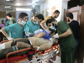 FILE - In this Sept. 6, 2016, file photo, provided by the Syrian anti-government activist group Aleppo Media Center (AMC), shows medical staff treating a man suffering from breathing difficulties inside a hospital in Aleppo, Syria after a chemical attack. Rival U.S. and Russian resolutions to extend the mandate of experts trying to determine who was responsible for chemical attacks in Syria were defeated Thursday, Nov. 16, 2017, at a United Nations Security Council meeting. (Aleppo Media Center via AP, File)