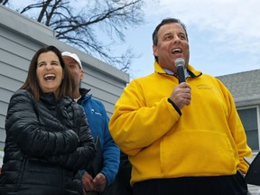 FILE- In this Jan. 31, 2014, file photo, first lady Mary Pat Christie, left, laughs as New Jersey Gov. Chris Christie greet volunteers and family and neighbors outside a renovated home that was heavily damaged by Superstorm Sandy in Moonachie, N.J. Christie and first lady Mary Pat Christie are expected to be on hand Monday, Nov. 20, 2017, when a new access road to Central Park of Morris County is christened "Governor Chris Christie Way."(AP Photo/Mel Evans, File)