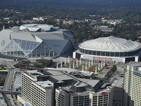FILE- In this Nov. 1, 2017, file photo, the Georgia Dome is seen at right with the Mercedes-Benz stadium at left in Atlanta. The Georgia Dome is scheduled to be imploded Monday, Nov. 20. The dome was not only the former home of the Atlanta Falcons but also the site of two Super Bowls, 1996 Olympics Games events and NCAA basketball tournaments among other major events. (AP Photo/Mike Stewart, File)