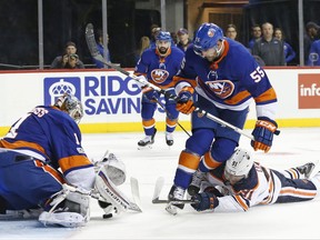 New York Islanders defenseman Johnny Boychuk (55) defends against a shot by Edmonton Oilers left wing Drake Caggiula (91) who collides with Boychuk as Islanders goalie Thomas Greiss (1) of Germany makes a save during the first period of an NHL hockey game in New York, Tuesday, Nov. 7, 2017. (AP Photo/Kathy Willens)
