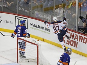 New York Islanders Nick Leddy, left, and and Islanders goalie Thomas Greiss (1) of Germany skate off as Edmonton Oilers center Connor McDavid (97) celebrates his game-winning overtime goal in the Oilers 2-1 victory over the Islanders in an NHL hockey game in New York, Tuesday, Nov. 7, 2017. (AP Photo/Kathy Willens)