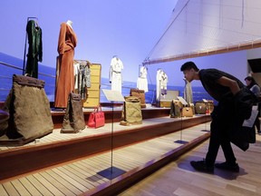 A visitor views items in "The Rise of Yachting" section, part of the "Volez, Voguez, Voyagez," Louis Vuitton exhibit, in the former American Stock Exchange building, in New York Financial District, Monday, Nov. 6, 2017. The luxury French brand, founded in the mid-19th century, is telling its story with a free, museum-like exhibition of artifacts, products and immersive displays. The exhibition is on view at the American Stock Exchange Building in Lower Manhattan until Jan. 7. (AP Photo/Richard Drew)