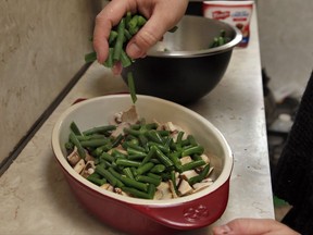 Ruthy Kirwan, of Percolate Kitchen, puts a layer of the fresh cut, blanched green beens on the sliced mushrooms in the gratin dish, as she prepares her version of the classic Thanksgiving favorite Green Been Casserole, in her apartment kitchen in the Queens borough of New York, Wednesday, Nov. 8, 2017. Before actors perform a play for an audience, they run a dress rehearsal to look for kinks that need fixing before the show opens. Traditional Thanksgiving dinner is a big production that can benefit from rehearsal, too, say some veteran hosts. (AP Photo/Richard Drew)