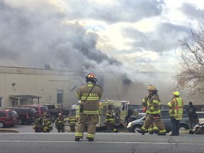 Firefighters work at the scene of of a fire Monday, Nov. 20, 2017, at the Verla International cosmetics factory on Temple Hill Road in New Windsor, NY. Authorities say two explosions and a fire at the cosmetics factory in the Hudson Valley have left numerous people injured, including firefighters caught in the second blast.  (Allyse Pulliam/Times Herald-Record via AP)