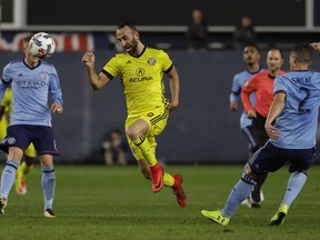 Columbus Crew's Justin Meram (9) is defended by New York City FC's Ben Sweat (2) during the first half of an MLS Eastern Conference semifinal soccer match Sunday, Nov. 5, 2017, in New York. (AP Photo/Mark Lennihan)