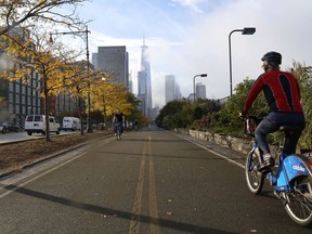 A cyclist rides along the reopened West Side bike path, Thursday, Nov. 2, 2017, in New York. A man in a rented pickup truck mowed down pedestrians and cyclists along the busy bike path near the World Trade Center memorial on Tuesday, killing several and seriously injuring others in what the mayor called "a particularly cowardly act of terror." (AP Photo/Mark Lennihan)