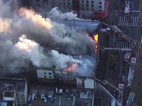 In this image taken from video provided by WABC, firefighters battle a large fire on the top floor of an apartment building in New York City's Harlem neighborhood. The Fire Department of New York says 170 firefighters are at the scene. There are no reports of injuries. (WABC via AP)