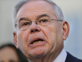 FILE - In this Nov. 16, 2017 file photo, Sen. Bob Menendez, D-N,J, speaks to reporters in front of the courthouse in Newark, N.J., after the jury in his federal bribery trial failed to reach a verdict. Defense attorney Jonathan Cogan says he doesn't expect the Department of Justice to spend a long time determining whether to retry Menendez and his longtime friend Salomon Melgen. (AP Photo/Seth Wenig)