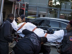 FILE- In this Oct. 31, 2017 file photo, emergency personnel carry a man into an ambulance after a man drove a rented pick-up truck onto a busy bicycle path near New York City's World Trade Center in New York. The terrorist truck attack on a Manhattan bike path that killed eight people, five of them friends visiting from Argentina, also took a devastating toll on another group of foreign tourists. Three members of a family from Belgium were among a dozen people hospitalized, including the most severely wounded of all, Marion Van Reeth, a mother whose legs were so badly mangled they had to be amputated. (AP Photo/Andres Kudacki, File)