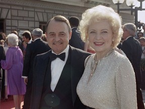 FILE- This Sept. 22, 1985, file photo shows John Hillerman, left, and Betty White, right, arriving at Emmy Awards in Pasadena, Calif. A spokeswoman for the family of Hillerman says the co-star of TV's "Magnum, P.I." has died. Hillerman was 84. Spokeswoman Lori De Waal said Hillerman died Thursday at his home in Houston. She said the cause of death has yet to be determined. (AP Photo/LIU, File)