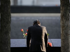 FILE--This Sept. 11, 2017, file photo shows a man standing at the edge of a waterfall pool at ground zero during a ceremony on the 16th anniversary of the 9/11 attacks in New York.  Since September 11, 2001, the neighborhood at the base of the World Trade Center has been transformed by new construction, and washed over by a wave of tourism. But this week's attack has reminded those who live, work, study and visit here of latent fears that this neighborhood would once again find itself in the crosshairs. (AP Photo/Seth Wenig, File)