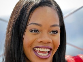 FILE- This Aug. 23, 2016, file photo shows U.S. gymnastics team member Gabby Douglas, at the Empire State Building in New York.  Douglas says she is among the group of athletes sexually abused by a former team doctor. Douglas, the 2012 Olympic all-around champion and a three-time gold medalist, wrote in an Instagram post Tuesday, Nov. 21, 2017, that she waited so long to reveal the abuse by Larry Nassar because she was part of a group "conditioned to stay silent." (AP Photo/Bebeto Matthews, File)